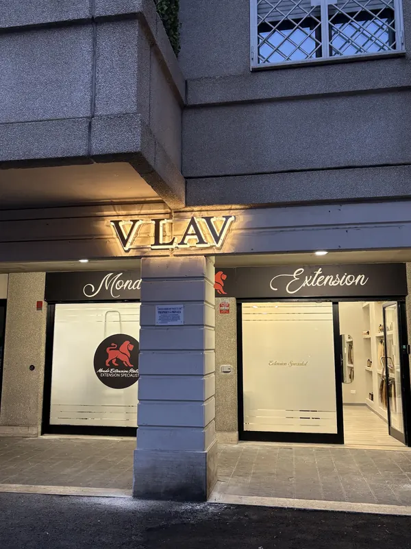 L'insegna luminosa V LAV accesa la sera sopra la vetrina con il leone rosso, in Via del Pianeta Saturno